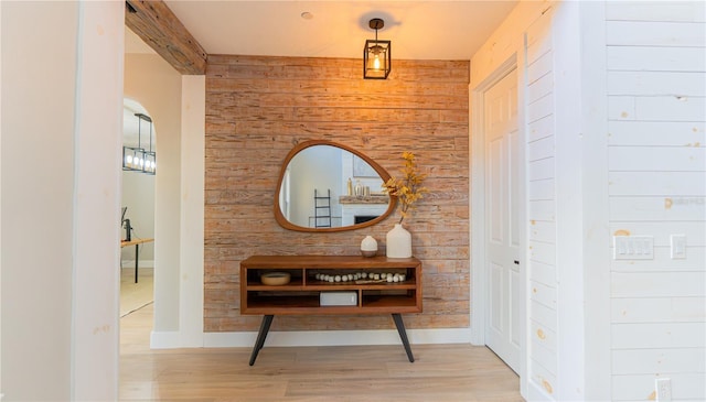 corridor featuring light hardwood / wood-style floors and wood walls