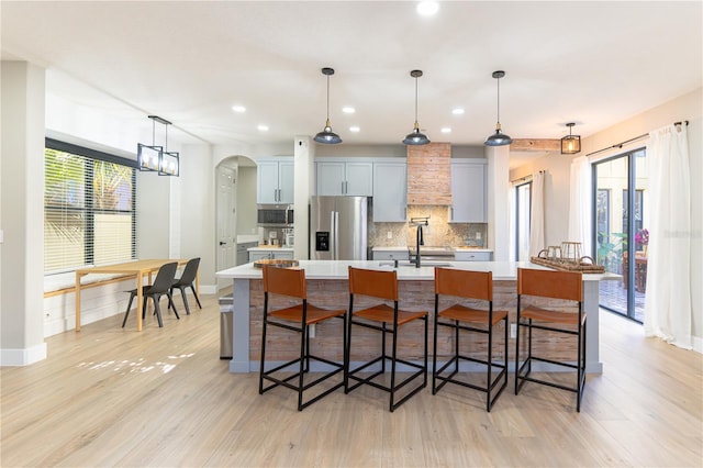 kitchen featuring hanging light fixtures, a breakfast bar area, a spacious island, and appliances with stainless steel finishes