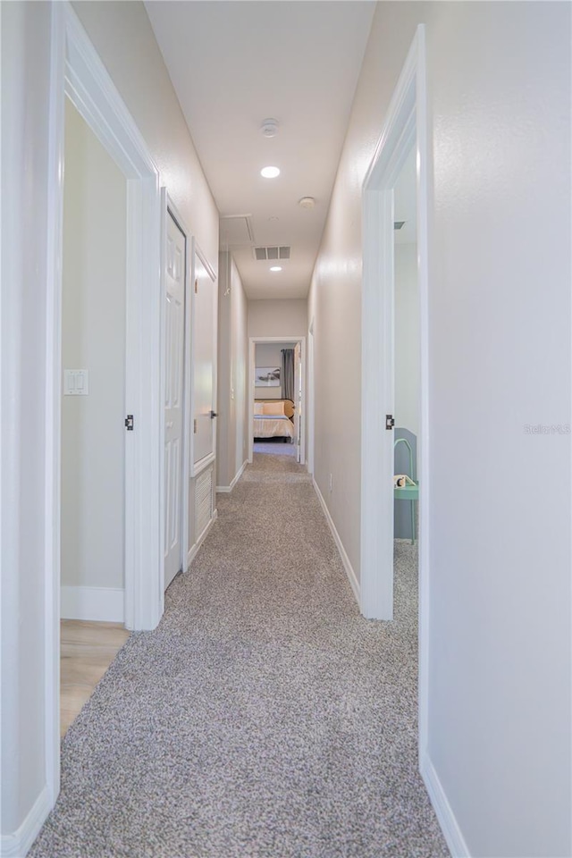 hallway featuring light colored carpet