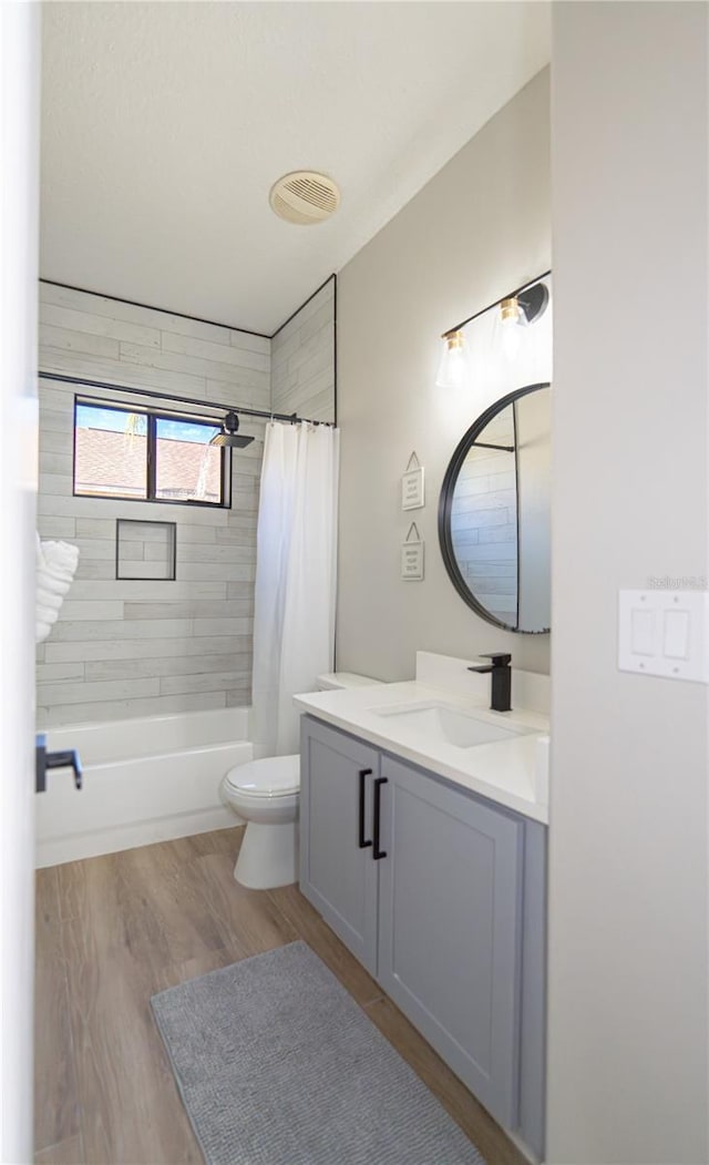 full bathroom with vanity, hardwood / wood-style floors, toilet, and shower / bathtub combination with curtain