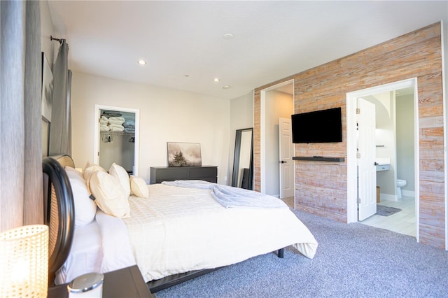 carpeted bedroom with ensuite bath, a closet, and a walk in closet