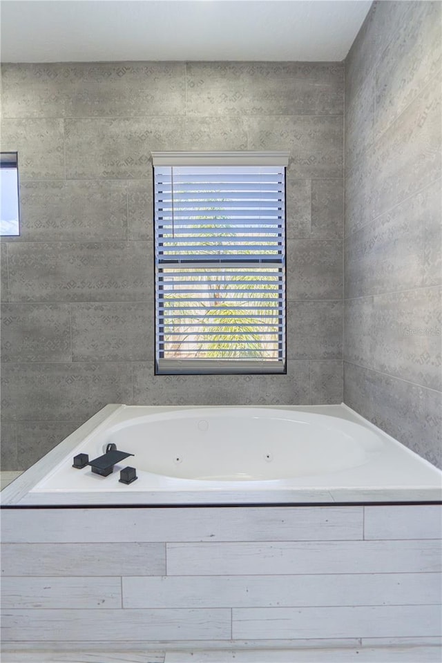 bathroom with tile walls and tiled tub