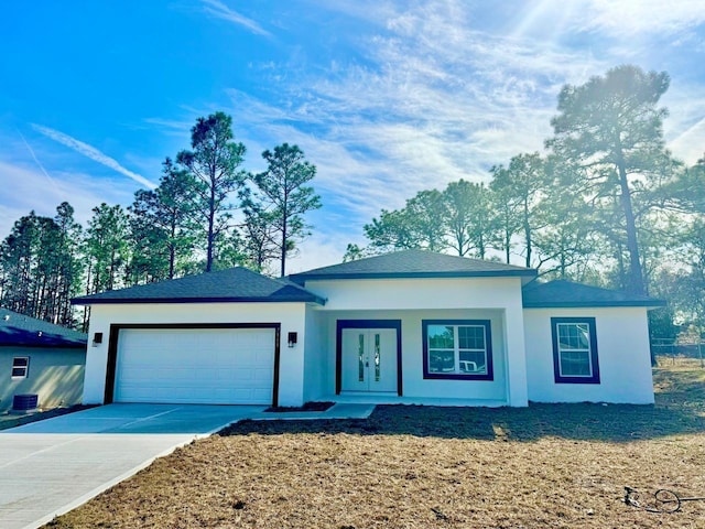 view of front of home with a garage and central AC