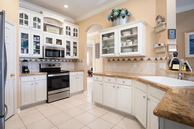 kitchen with sink, light tile patterned floors, white cabinets, and appliances with stainless steel finishes