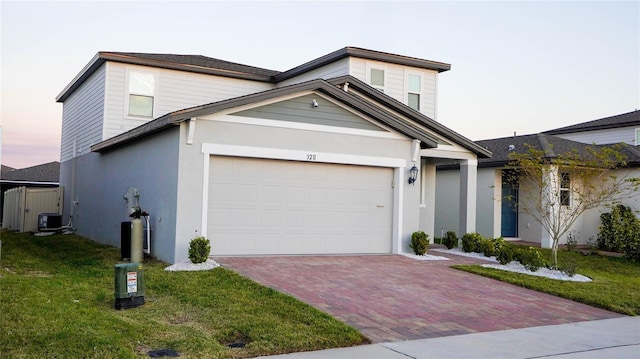 view of front of property with a garage, a yard, and cooling unit