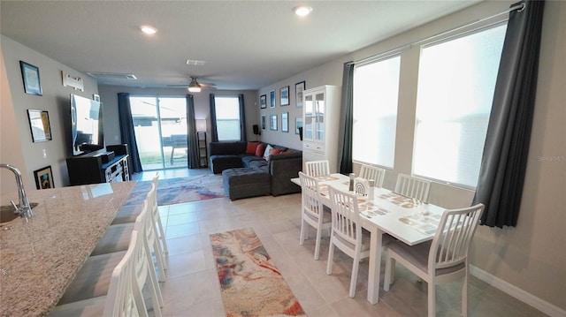 dining area featuring light tile patterned flooring, ceiling fan, and sink