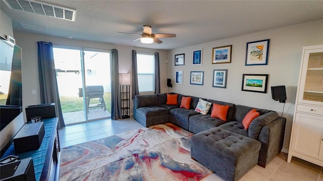 living room featuring ceiling fan, plenty of natural light, and light tile patterned floors