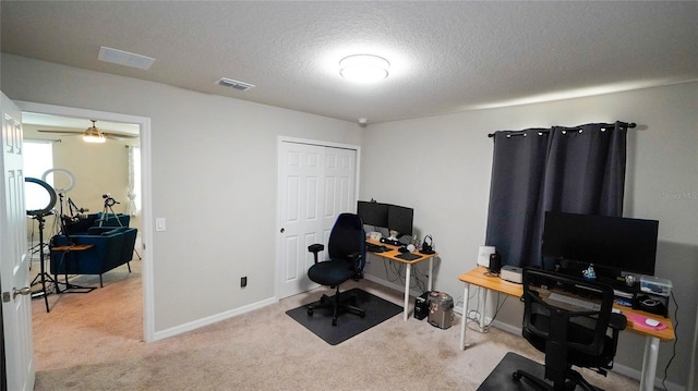 carpeted office featuring a textured ceiling