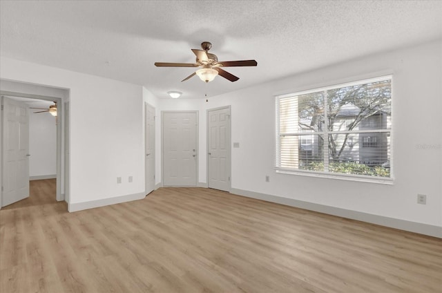 unfurnished bedroom with ceiling fan, a textured ceiling, and light wood-type flooring