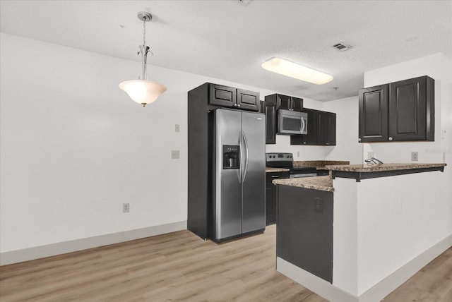 kitchen featuring hanging light fixtures, light hardwood / wood-style floors, kitchen peninsula, stainless steel appliances, and a textured ceiling