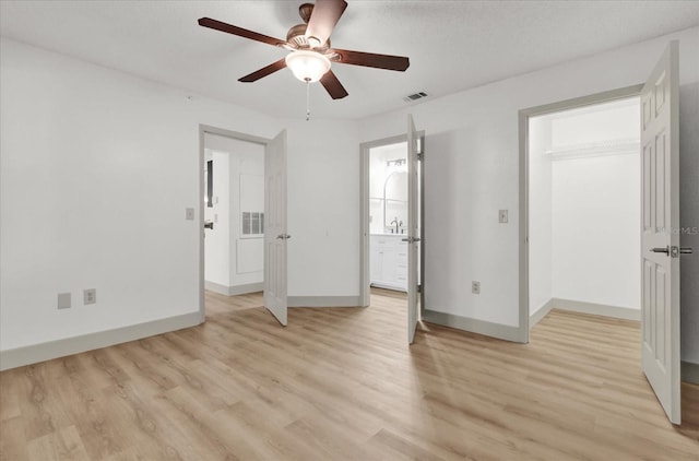 unfurnished bedroom with sink, light hardwood / wood-style flooring, ceiling fan, and ensuite bathroom