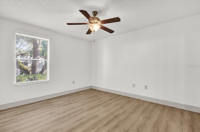 empty room with ceiling fan, light hardwood / wood-style floors, and a textured ceiling