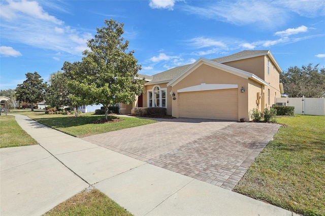 ranch-style house featuring a garage and a front lawn