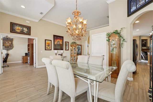 dining room featuring crown molding, an inviting chandelier, and light hardwood / wood-style floors