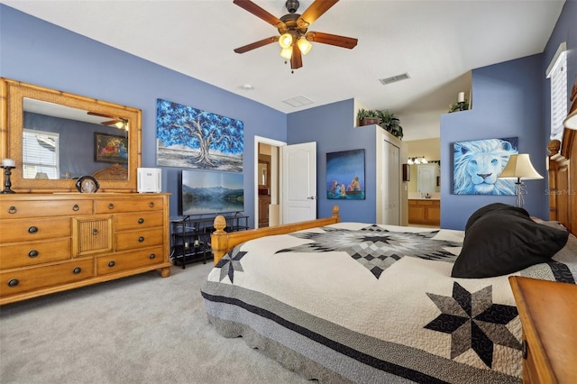 bedroom with light carpet, connected bathroom, and ceiling fan