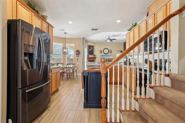 kitchen with decorative light fixtures, light brown cabinets, and stainless steel refrigerator with ice dispenser