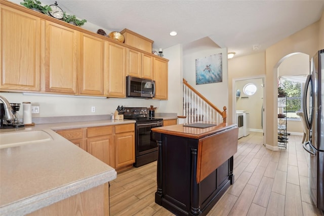 kitchen with appliances with stainless steel finishes, sink, and light brown cabinets