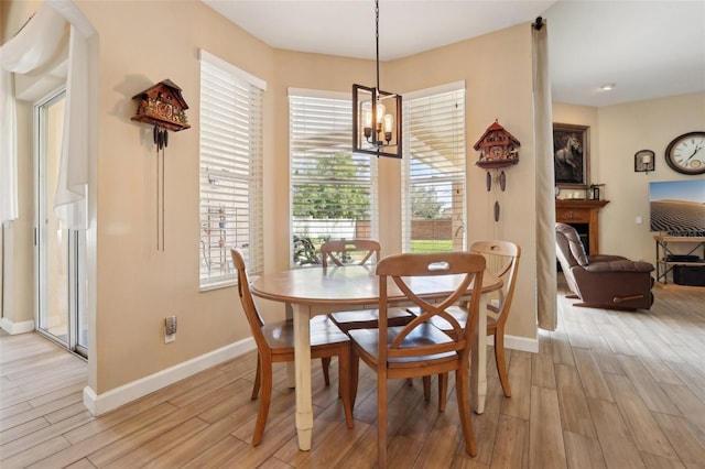 dining space featuring a healthy amount of sunlight, a notable chandelier, and light hardwood / wood-style floors