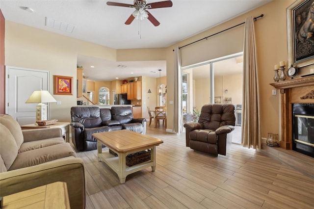 living room featuring ceiling fan and light hardwood / wood-style flooring