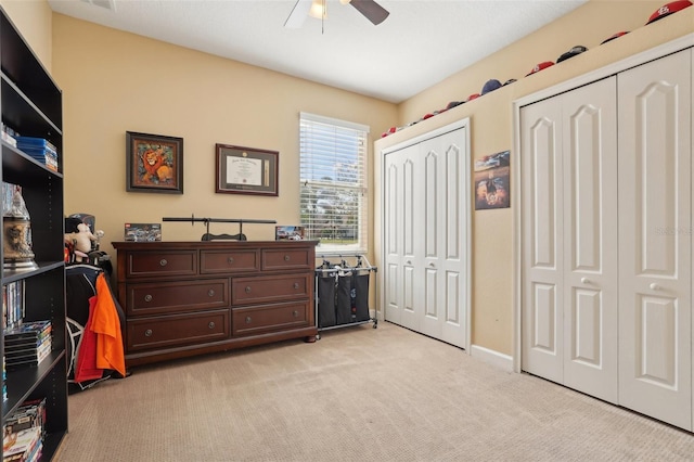 carpeted bedroom featuring two closets and ceiling fan