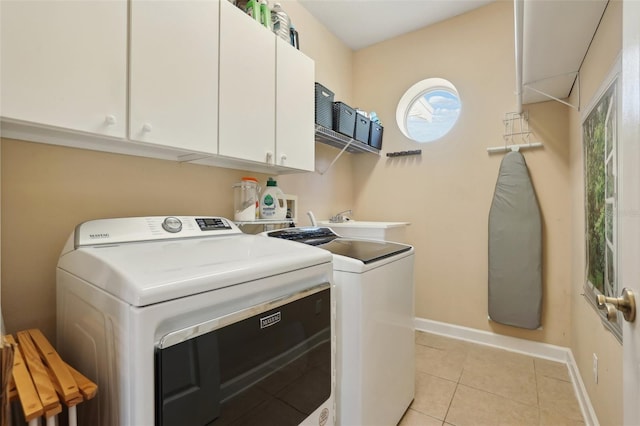 laundry room with cabinets, light tile patterned flooring, washer and dryer, and sink