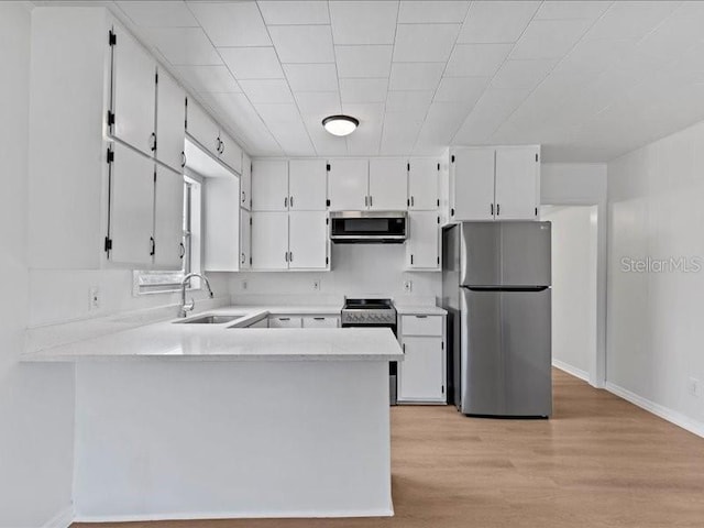 kitchen featuring sink, kitchen peninsula, white cabinets, and appliances with stainless steel finishes