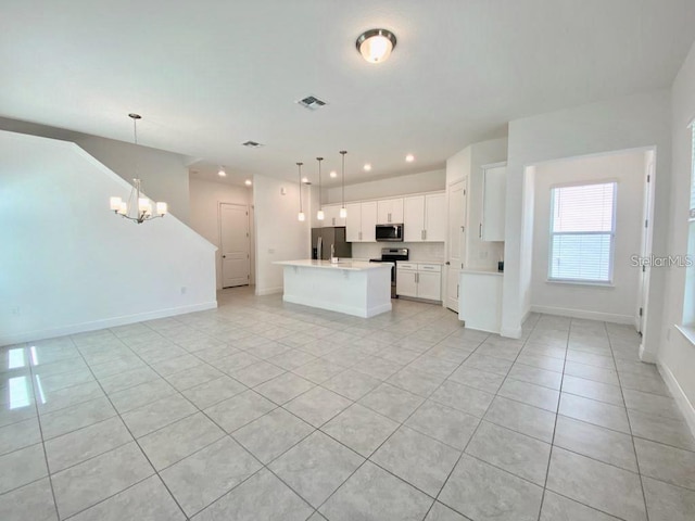 kitchen featuring pendant lighting, appliances with stainless steel finishes, an island with sink, and white cabinets