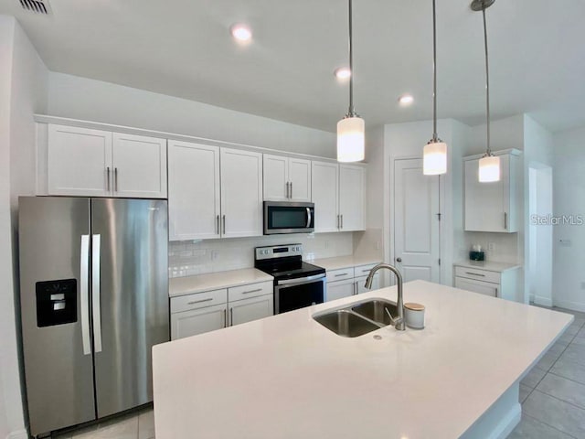 kitchen featuring stainless steel appliances, white cabinetry, and pendant lighting