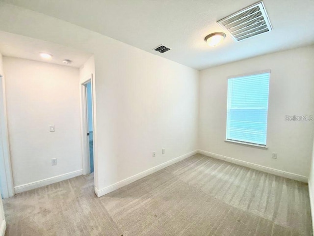 spare room featuring light colored carpet