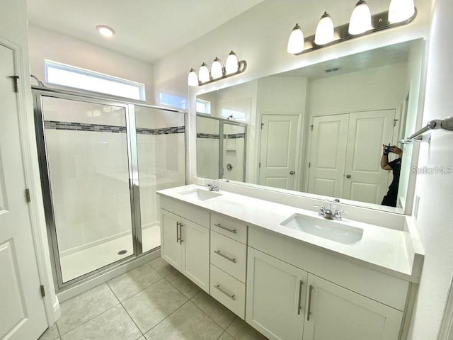 bathroom featuring tile patterned floors, vanity, and a shower with door