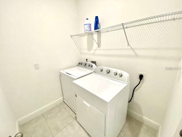 laundry area with washer and dryer and light tile patterned flooring