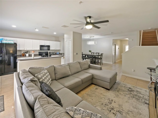 living room featuring sink, light tile patterned floors, and ceiling fan