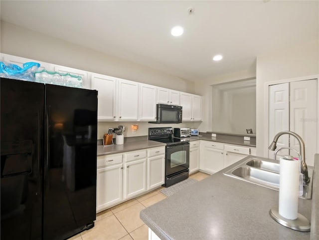 kitchen with light tile patterned flooring, white cabinets, sink, and black appliances