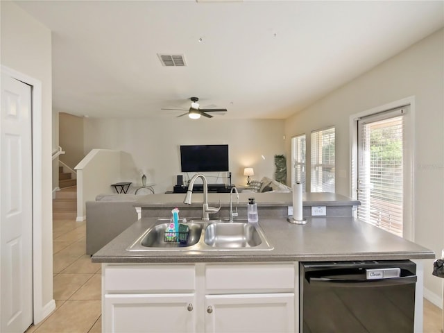 kitchen with light tile patterned flooring, white cabinetry, dishwasher, sink, and a center island with sink