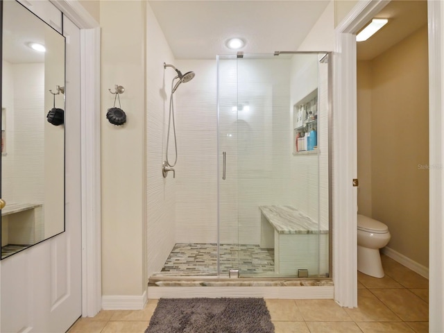 bathroom with tile patterned flooring, toilet, and walk in shower