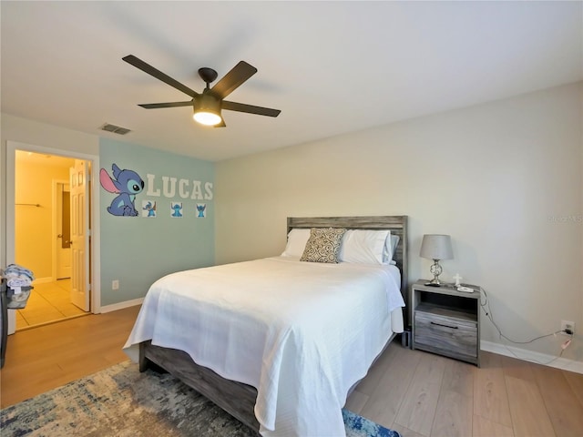 bedroom featuring ensuite bathroom, ceiling fan, and light hardwood / wood-style flooring