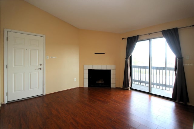 unfurnished living room featuring a tile fireplace and dark hardwood / wood-style floors