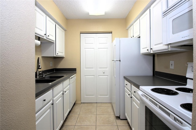 kitchen featuring sink, light tile patterned floors, white cabinets, and white appliances