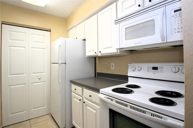 kitchen featuring white cabinetry, white appliances, a textured ceiling, and light tile patterned floors