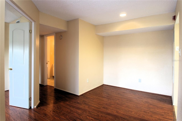 empty room featuring dark hardwood / wood-style floors and a textured ceiling