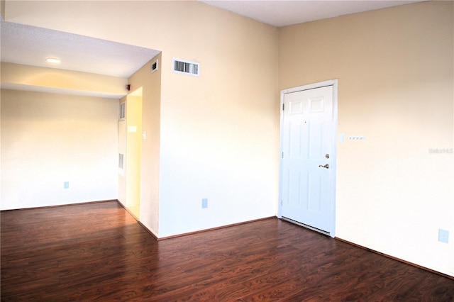 empty room with dark hardwood / wood-style flooring