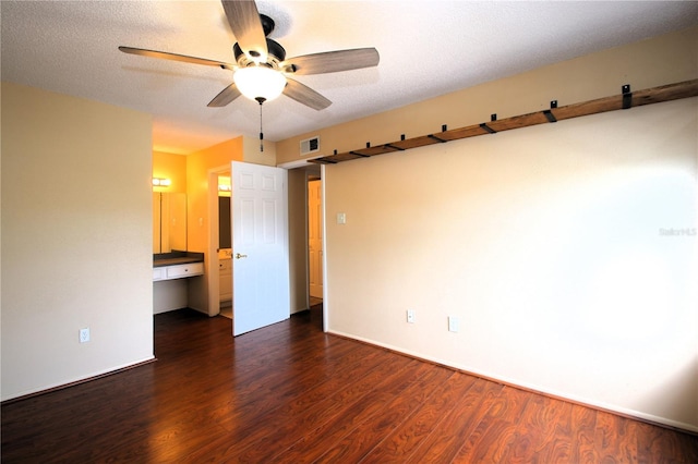 unfurnished room with ceiling fan, a textured ceiling, and dark hardwood / wood-style flooring