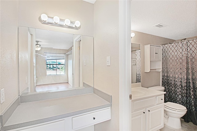 bathroom with vanity, ceiling fan, toilet, and a textured ceiling