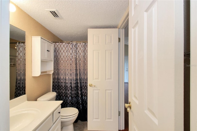 bathroom with vanity, toilet, a shower with shower curtain, and a textured ceiling