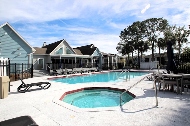 view of pool with a hot tub and a patio