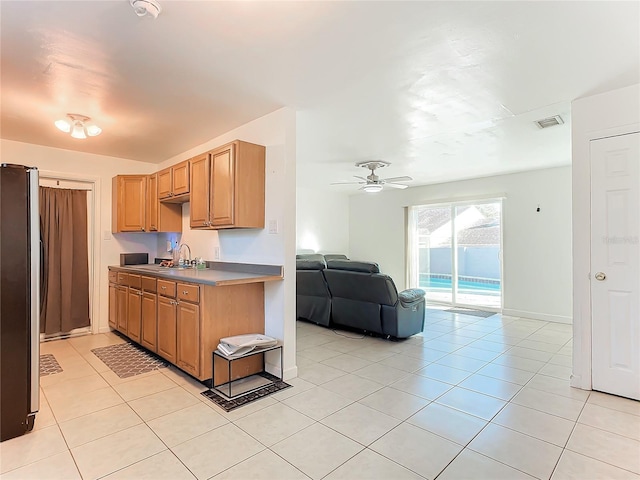 kitchen with sink, stainless steel refrigerator, ceiling fan, and light tile patterned flooring