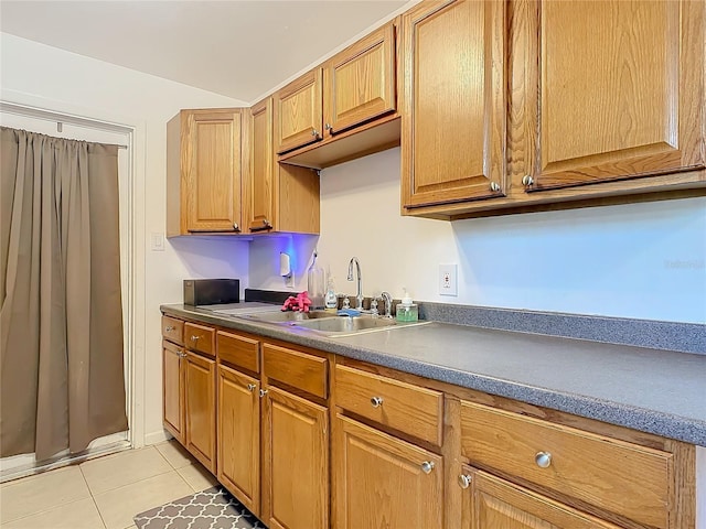 kitchen featuring vaulted ceiling, sink, and light tile patterned floors