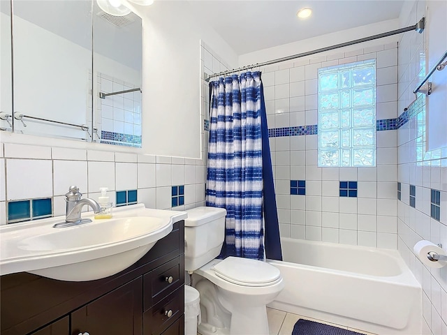 full bathroom with shower / tub combo with curtain, toilet, tile walls, vanity, and tile patterned flooring