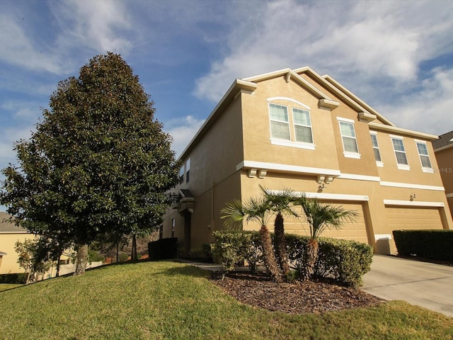 view of side of property featuring a garage, a yard, driveway, and stucco siding