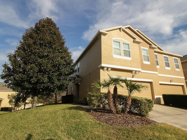 view of side of home with a garage, concrete driveway, a lawn, and stucco siding